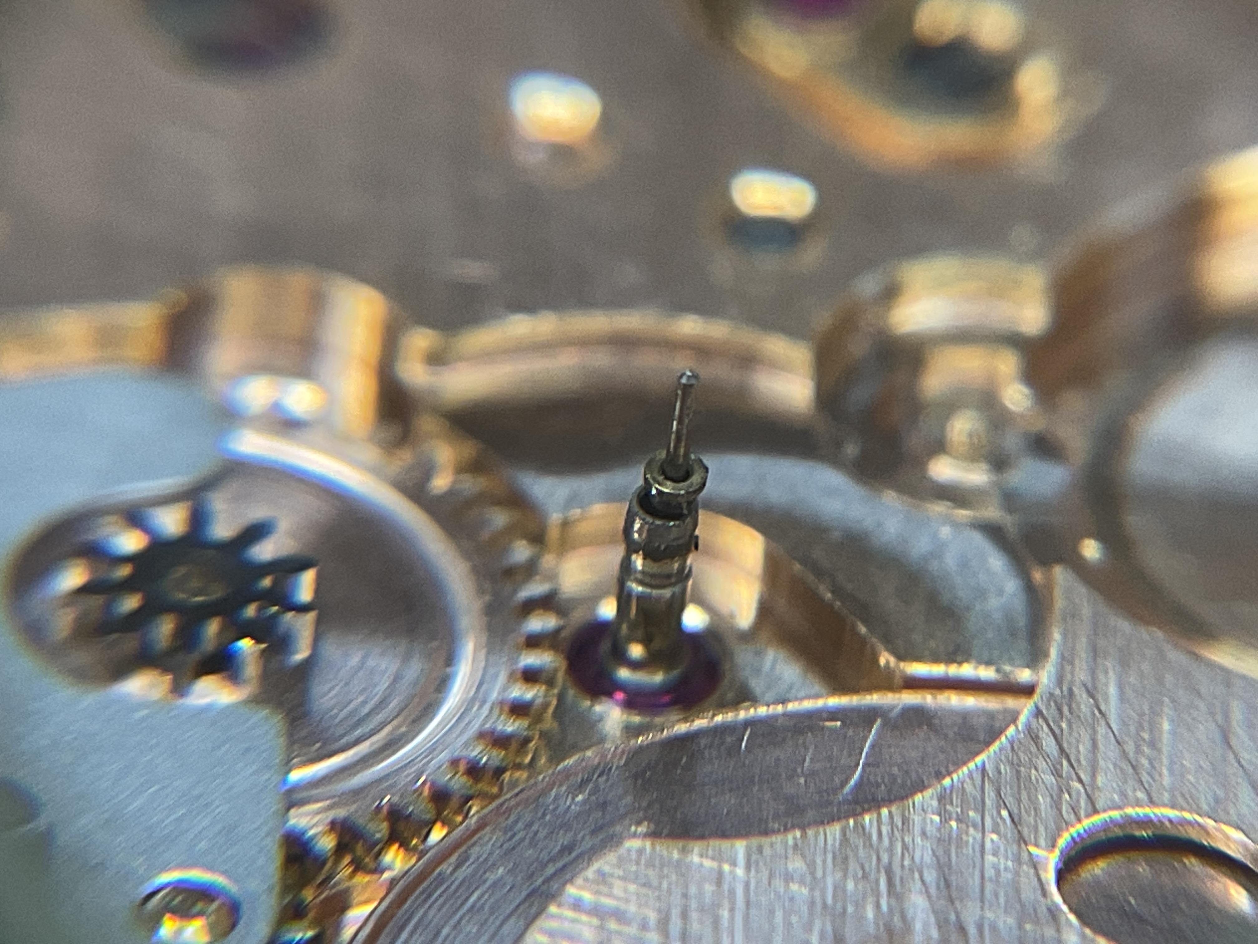 Under the loupe — the central-seconds pinion at the center of the movement.