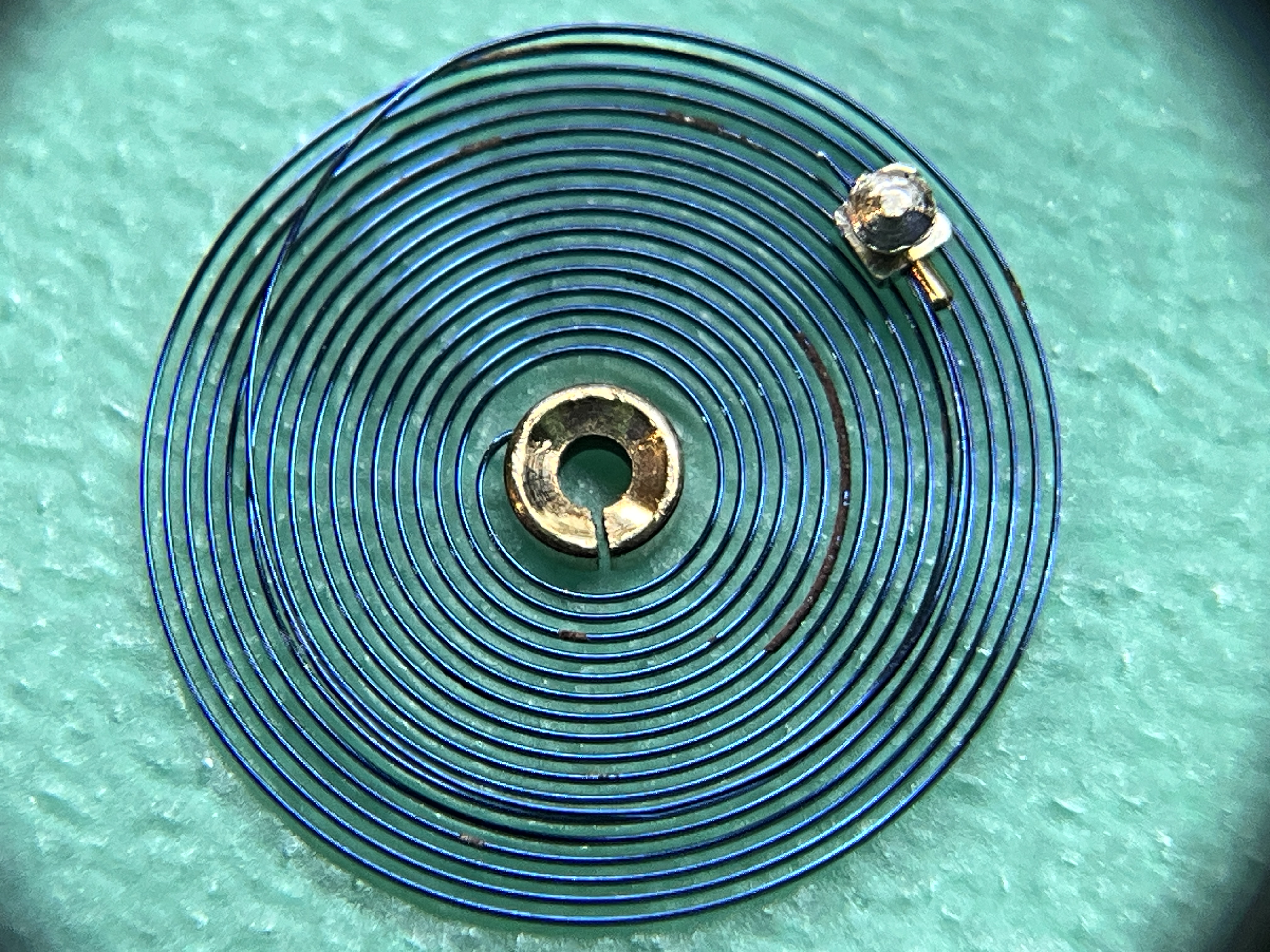 Surface rust on the hairspring — neutralized mechanically, then treated chemically.
