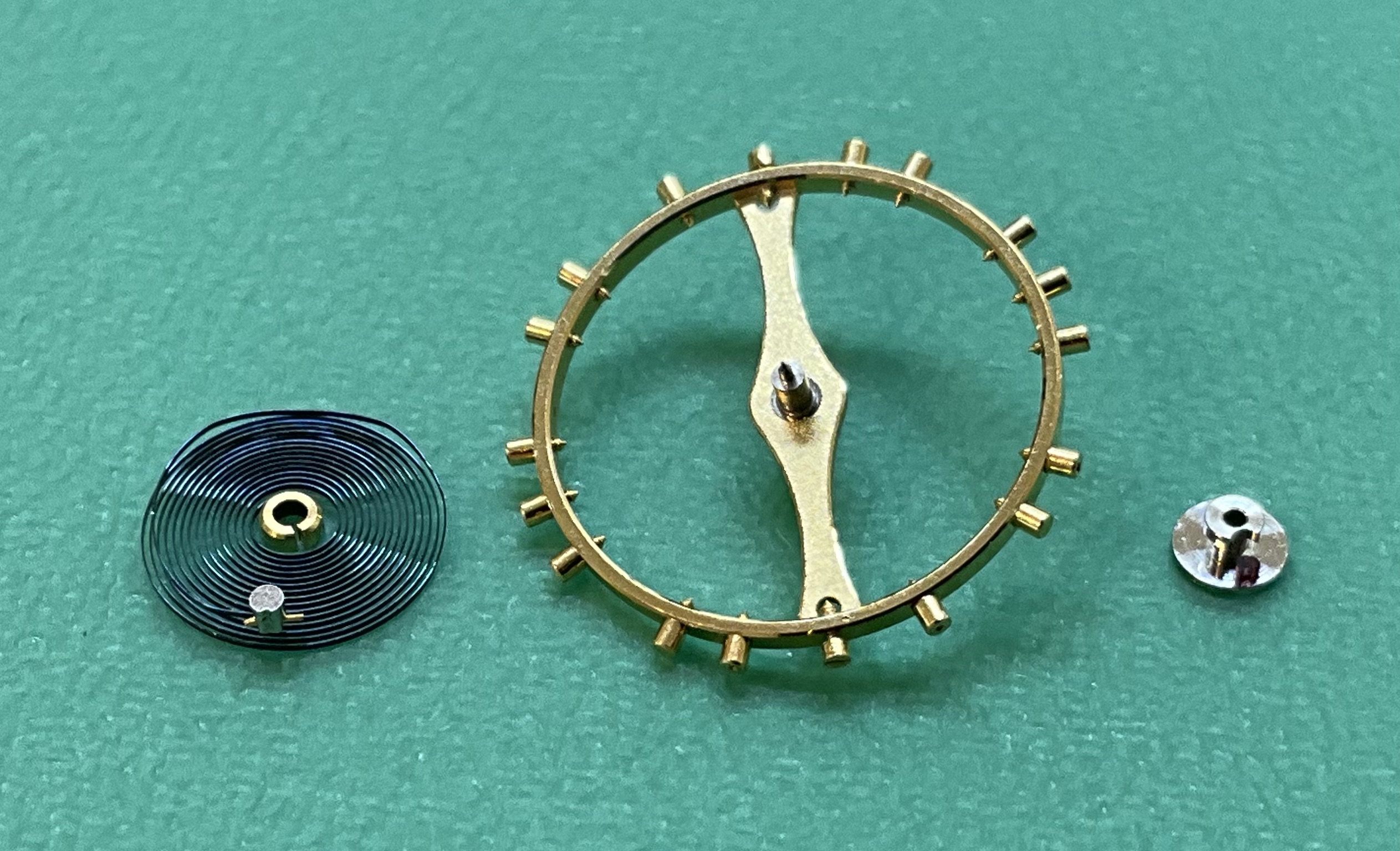 The balance disassembled — wheel, hairspring, and cap — for re-staffing and poising.