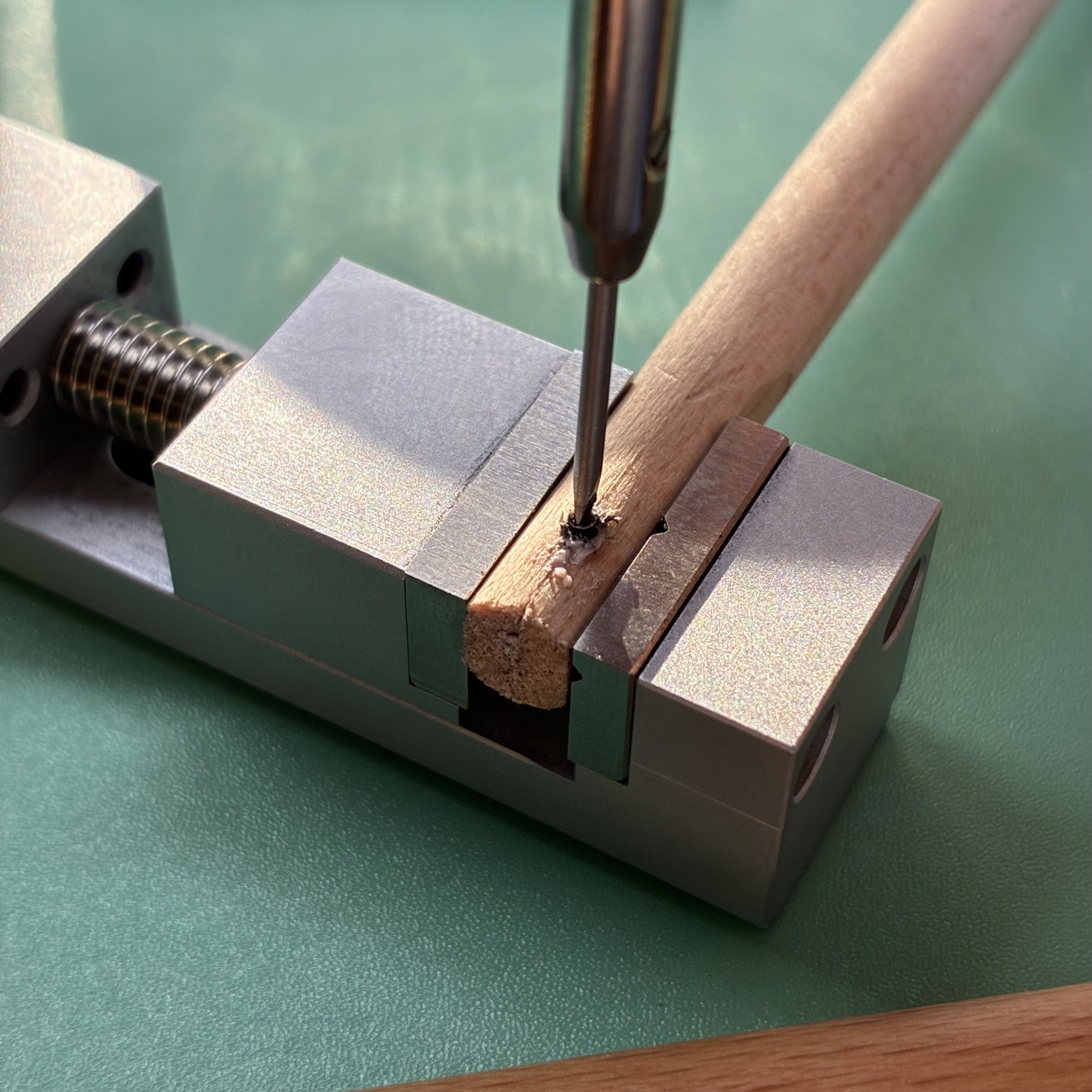 Polishing a screw's threads in pegwood charged with polishing paste.